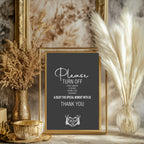 A framed wedding sign with a dark charcoal background and white text reading 'Please Turn Off' and 'Thank You,' styled in a warm home setting with dried grasses in gold and clear vases.