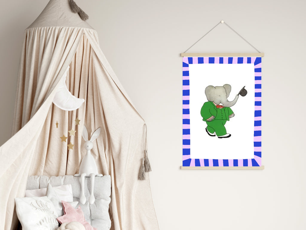 Framed picture of an elephant in a green outfit hanging on a wall next to a crib with canopy.