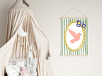 Children's room with a canopy bed and a framed picture of a bird on a green striped background.