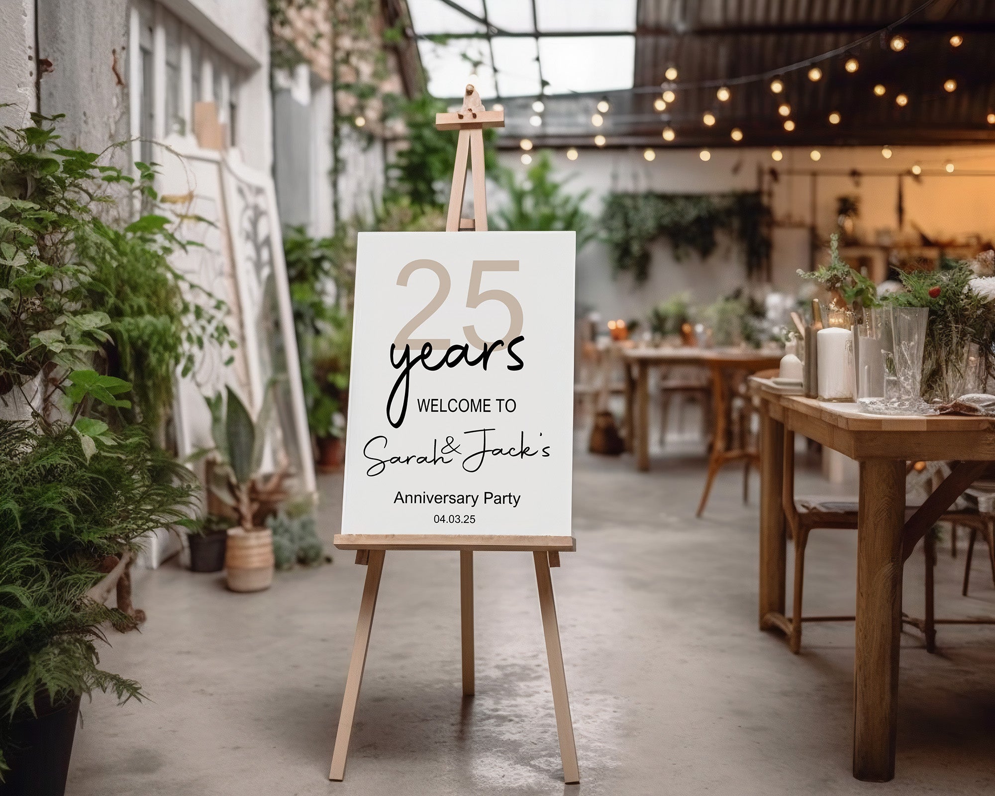 Anniversary party sign on an easel in a decorated indoor setting with tables and plants.