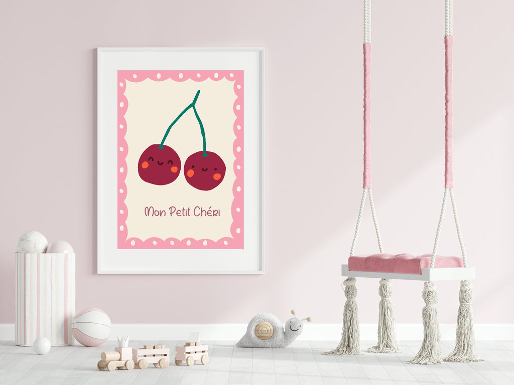 Framed illustration of cherries with a pink border on a light pink wall, next to a children's swing.