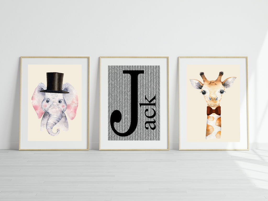 Three framed prints of an elephant, letter 'J', and giraffe on a white wall.