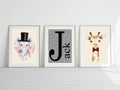 Three framed prints of an elephant, letter 'J', and giraffe on a white wall.