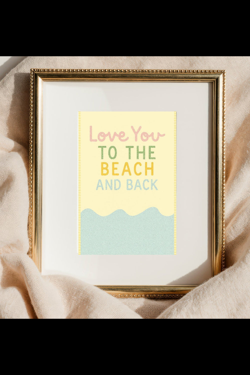 Framed print with 'Love You to the Beach and Back' text on a soft fabric background