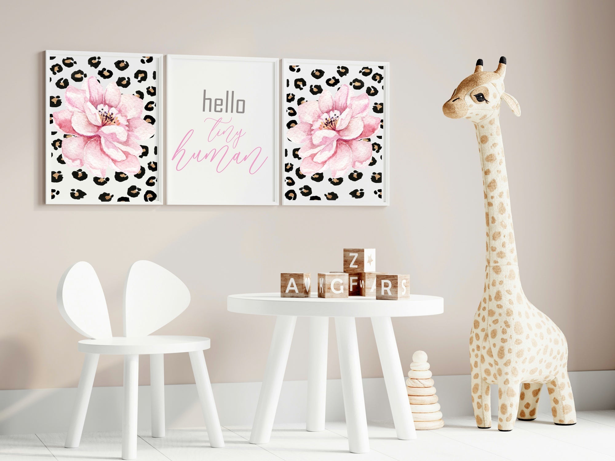 Nursery with floral wall art, children's chair, small table, and stuffed giraffe.