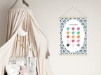 Color mixing chart hanging on a wall next to a crib with canopy