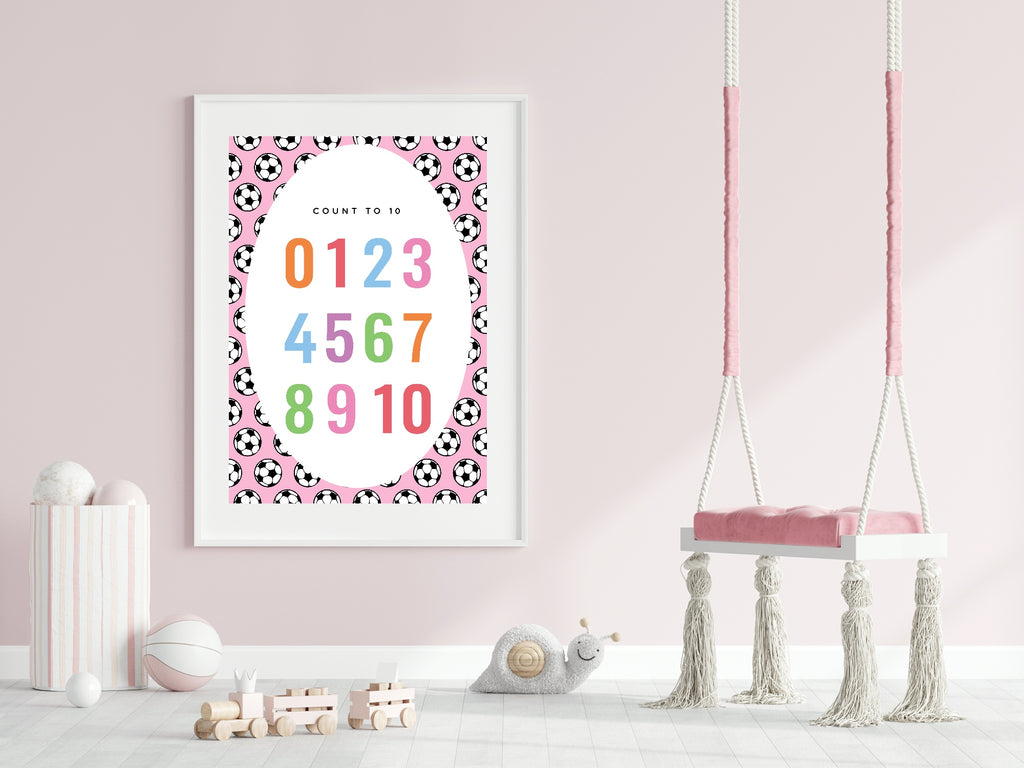 Framed children's poster with numbers and soccer ball pattern on a pink wall with a swing in the background.