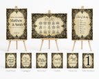 A coordinated wedding stationery set displayed on small wooden easels, including a guest book, unplugged sign, pick a seat sign, confetti sign, thank you sign, table numbers sign, and three matching printed cards. The design uses a distressed beige background with ornate black damask-style borders and elegant script text.