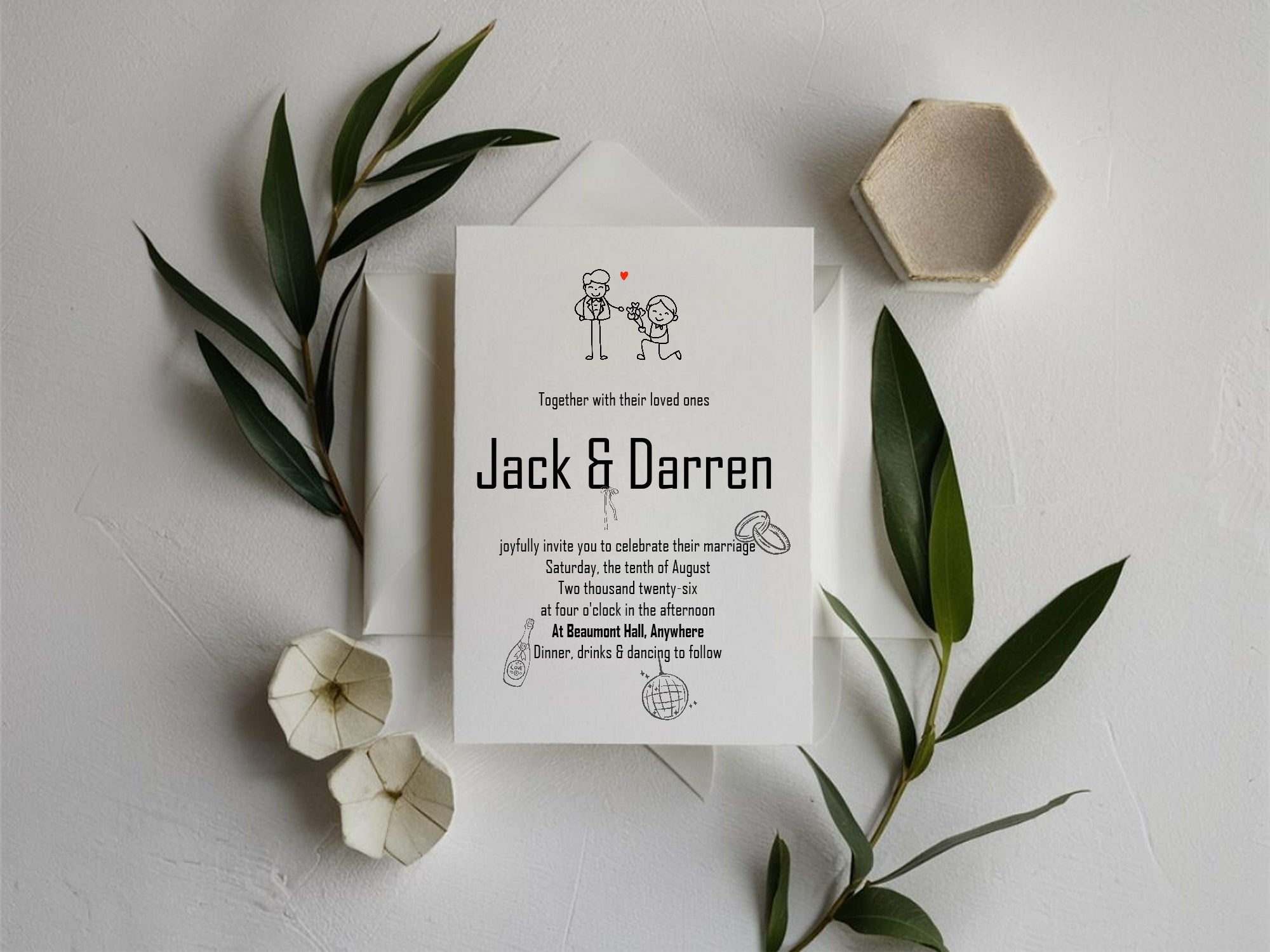 Wedding invitation card with 'Jack & Darren' on a white surface with green leaves and a small bowl.