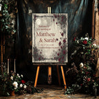 Moon and Rose wedding welcome sign on an easel in a dark floral setting