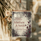 Moon and Rose wedding welcome sign with burgundy names and thorn border beside dried flowers